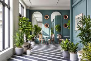 a corridor with potted plants on a floor with windows at Kimpton Cottonwood Hotel, an IHG Hotel in Omaha