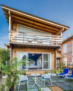 una casa con terrazza con sedie e patio di Living Room Beach Resort a Morjim