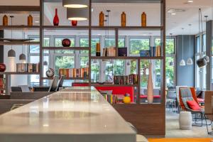a library with a long table and shelves of books at Campanile Frankfurt Offenbach in Offenbach