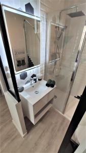 y baño blanco con lavabo y ducha. en Home&Work 101 - HYPERCENTRE - Parking à proximité, en Niort