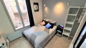 Dormitorio pequeño con cama y estante de libros en Home&Work 101 - HYPERCENTRE - Parking à proximité, en Niort