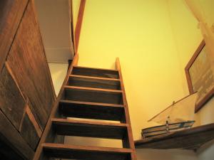 a wooden staircase in a room with yellow walls at Miti Miwiri in Ibo