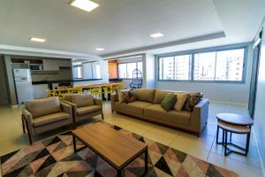 sala de estar con sofá, mesa y cocina en A Furninha Suites, en Torres