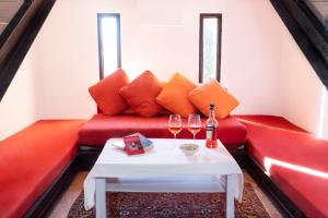 een rode bank met twee glazen wijn op een tafel bij Villa Avesa in Verona