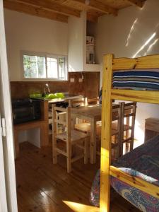 a bedroom with a bunk bed and a kitchen with a table at Las Zarinas 4 in Trapiche