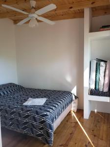 - une chambre avec un lit et un ventilateur de plafond dans l'établissement Las Zarinas 4, à Trapiche