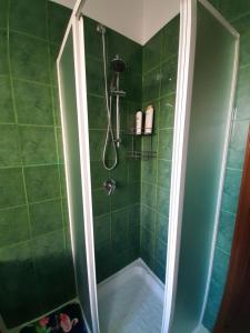 a bathroom with a shower with green tiles at Appartamento il tulipano in Assemini +9 photos