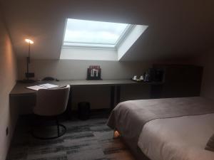 a bedroom with a bed and a desk at Hotel Charleroi Airport - Van Der Valk in Charleroi
