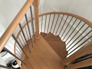 a wooden spiral staircase with a wooden rail at Southover Beach in Woolacombe