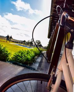 una bicicleta estacionada al lado de un edificio con un campo en Hotel Santa Cristina, en Durazno