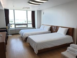 a hotel room with two beds and a large window at Good Day Airtel in Incheon