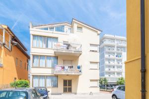 un edificio blanco con coches estacionados frente a él en Zenith, en Lido di Jesolo