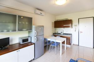 a kitchen with a refrigerator and a table with chairs at Torcello in Bibione