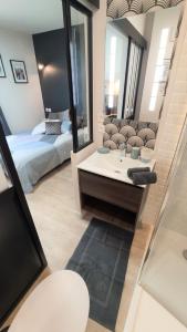 La salle de bains est pourvue d'un lit, d'un lavabo et d'un miroir. dans l'établissement Home&Work 201 - HYPERCENTRE - fibre et parking a proximité, à Niort