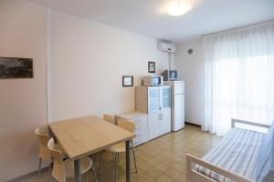 een keuken en eetkamer met een tafel en een koelkast bij La Zattera in Porto Santa Margherita di Caorle