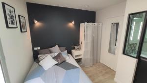 - une petite chambre avec un lit et une douche dans l'établissement Home&Work 201 - HYPERCENTRE - fibre et parking a proximité, à Niort