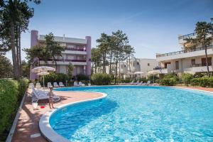 a swimming pool in front of a building at Ducale in Bibione