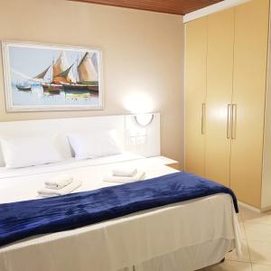 um quarto com uma cama grande e uma pintura na parede em Hotel Meaípe em Guarapari
