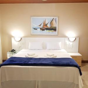 um quarto com uma cama grande com duas toalhas em Hotel Meaípe em Guarapari