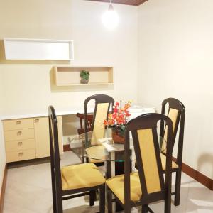 uma sala de jantar com uma mesa de vidro e cadeiras em Hotel Meaípe em Guarapari