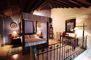 Un dormitorio con una cama con dosel en una habitación. en Hospederia Meson de la Dolores, en Calatayud