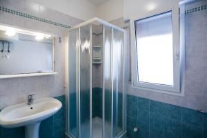 een badkamer met een wastafel en een glazen douche bij Ca' Mira Apartments in Caorle +37 foto's