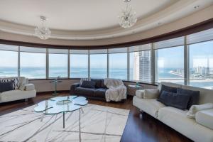 a living room with couches and a table and windows at EDEN'S Homes & Villas - KG Tower in Dubai