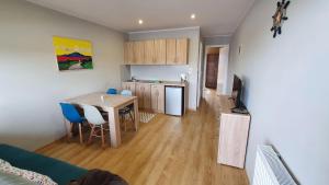 a living room with a kitchen and a table and chairs at Apartamenty Ster Darłówko in Darlowko +13 photos