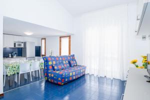 Una sala de estar con una silla y una cocina. en Sole B, en Bibione