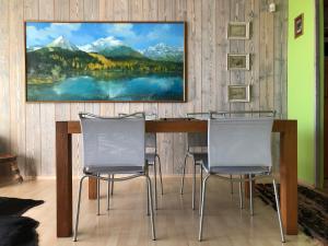 a dining room table with chairs and a painting on the wall at Villa Capri in Vysoké Tatry