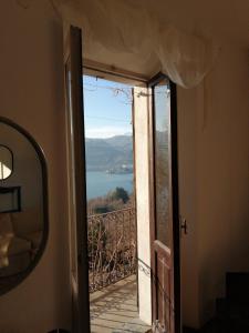 eine Tür, die auf einen Balkon mit Aussicht führt in der Unterkunft Balconata sul lago in Ameno