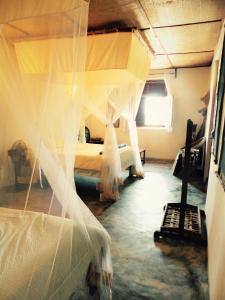 a bedroom with a bed with mosquito net at Miti Miwiri in Ibo