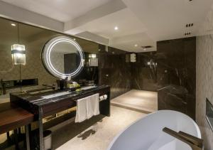 a bathroom with a tub and a large mirror at InterContinental Muscat, an IHG Hotel in Muscat