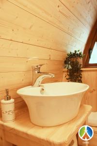 ein Badezimmer mit einer weißen Badewanne an einer Holzwand in der Unterkunft Camping lago 3 comuni in Alesso