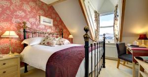 a bedroom with a bed and a chair and a window at The Edwardene in Keswick
