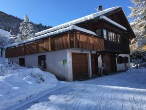 a house in the snow with a snow covered driveway at Vacances COURCHEVEL/les 3 Vallées in Bozel