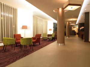 a lobby with chairs and a table in a building at Leonardo Hotel Derby in Derby