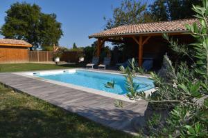 a swimming pool in a yard with a gazebo at Le Refuge des Épicuriens in Eymet
