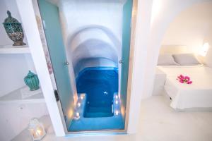 a water tunnel in a room with a bed at Kastro Oia Houses in Oia