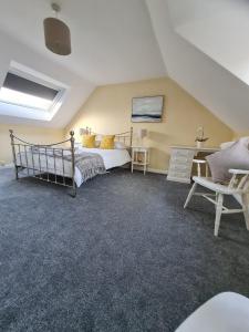 a bedroom with a bed and a couch and a chair at Self contained annexe in pretty Suffolk village in Bury Saint Edmunds