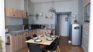 a kitchen with a table with chairs and a refrigerator at L'étape Normande in Fécamp