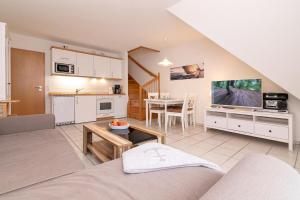 ein Wohnzimmer mit einem Sofa, einem TV und einem Tisch in der Unterkunft Gorch-Fock Park 9 in Timmendorfer Strand