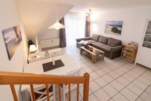 ein Wohnzimmer mit einem Sofa und einem Tisch in der Unterkunft Gorch-Fock Park 9 in Timmendorfer Strand