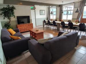 een woonkamer met banken en een tafel en een televisie bij Hoeve Cobelli in Noorbeek