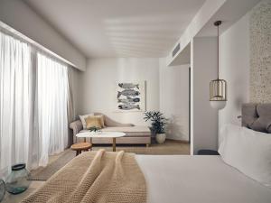 sypialnia z łóżkiem i salon w obiekcie The Royal Blue a Luxury Beach Resort w mieście Panormos