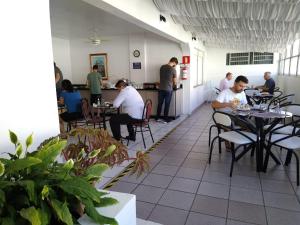 a group of people sitting at tables in a restaurant at Hotel Paraiso in Santa Maria