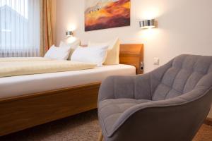 een hotelkamer met een bed en een stoel bij Parkhotel Lippstadt in Lippstadt