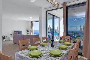 un comedor con una mesa con platos verdes. en Villa Maslina with heated Pool, en Veliko Brdo