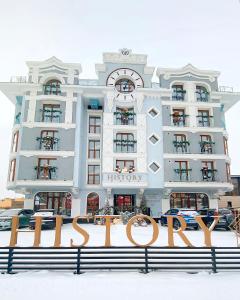 um grande edifício branco com um sinal na neve em HISTORY Boutique Hotel & SPA em Irkutsk