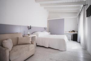 Habitación blanca con cama y sofá en Casa Fola - City Centre Rooms, en Verona